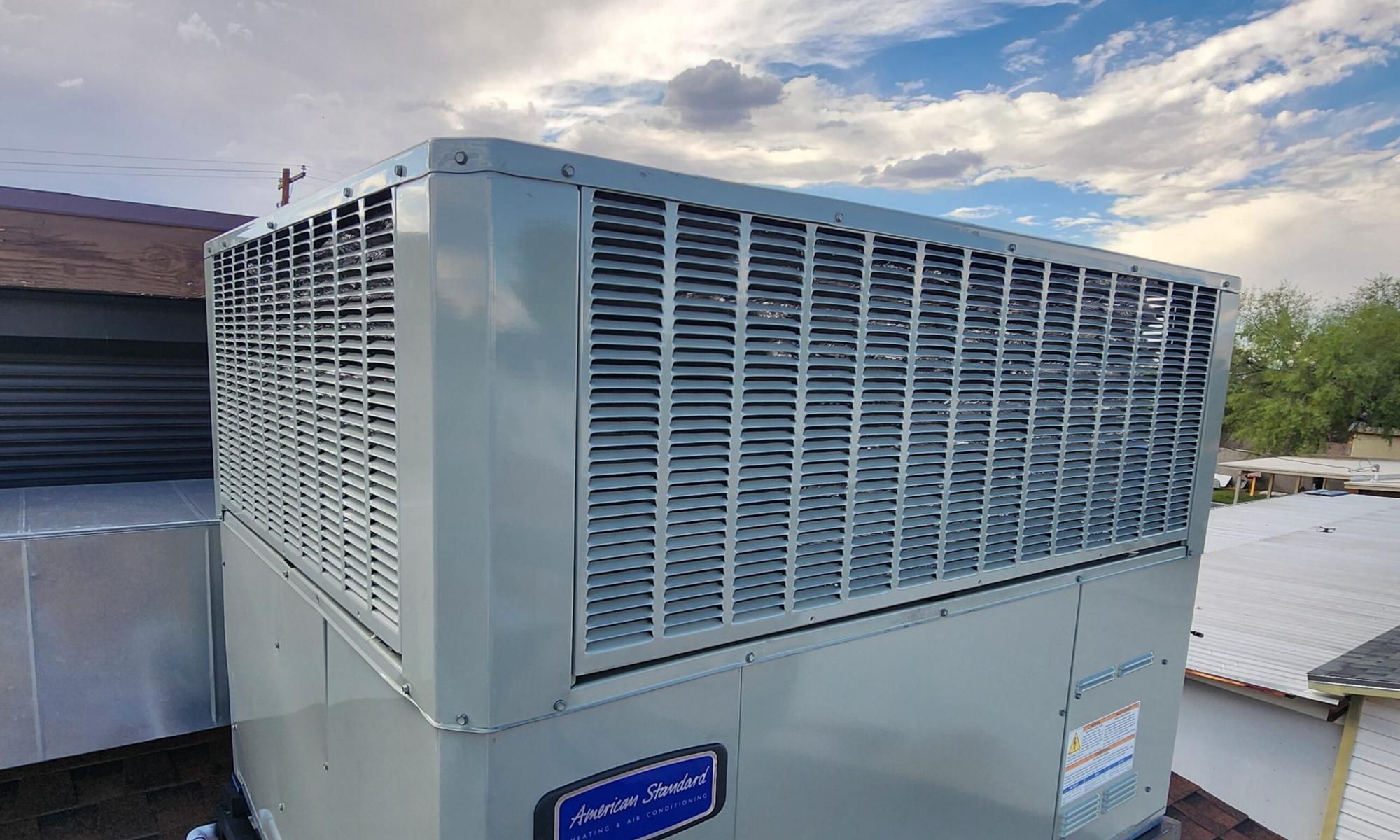 Rooftop HVAC package unit on a Tucson home under a bright desert sky